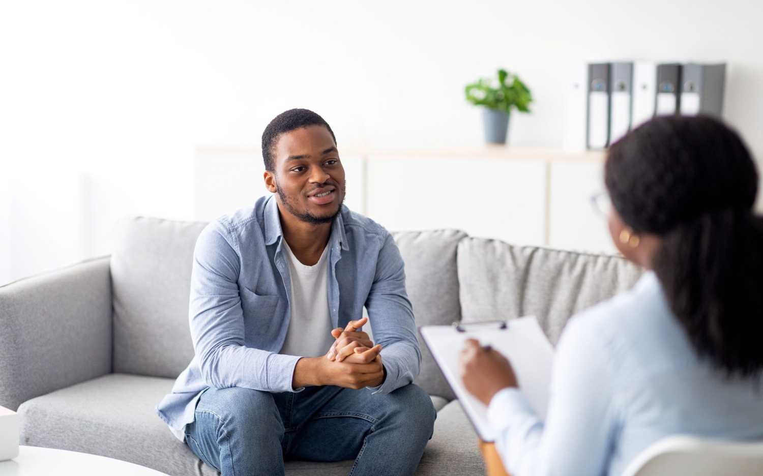 Man talking with a mental health professional during a counseling session, representing CorVel’s commitment to early intervention and virtual behavioral health care in workers’ compensation.