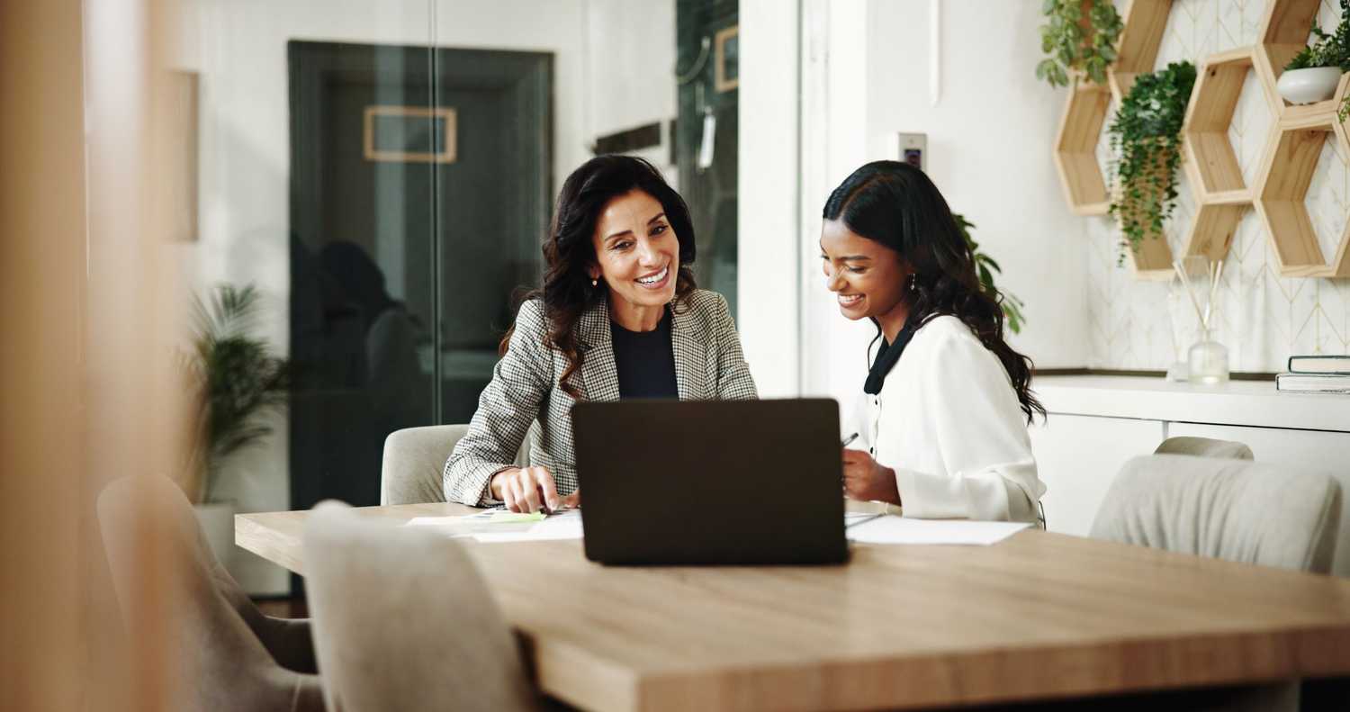 Two professionals collaborating at a laptop in a modern office, representing CorVel’s commitment to partnership, client understanding, and innovative TPA solutions that enhance claims management and risk outcomes.