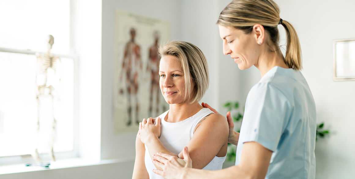 A physical therapist helping a patient with a stretch to improve recovery