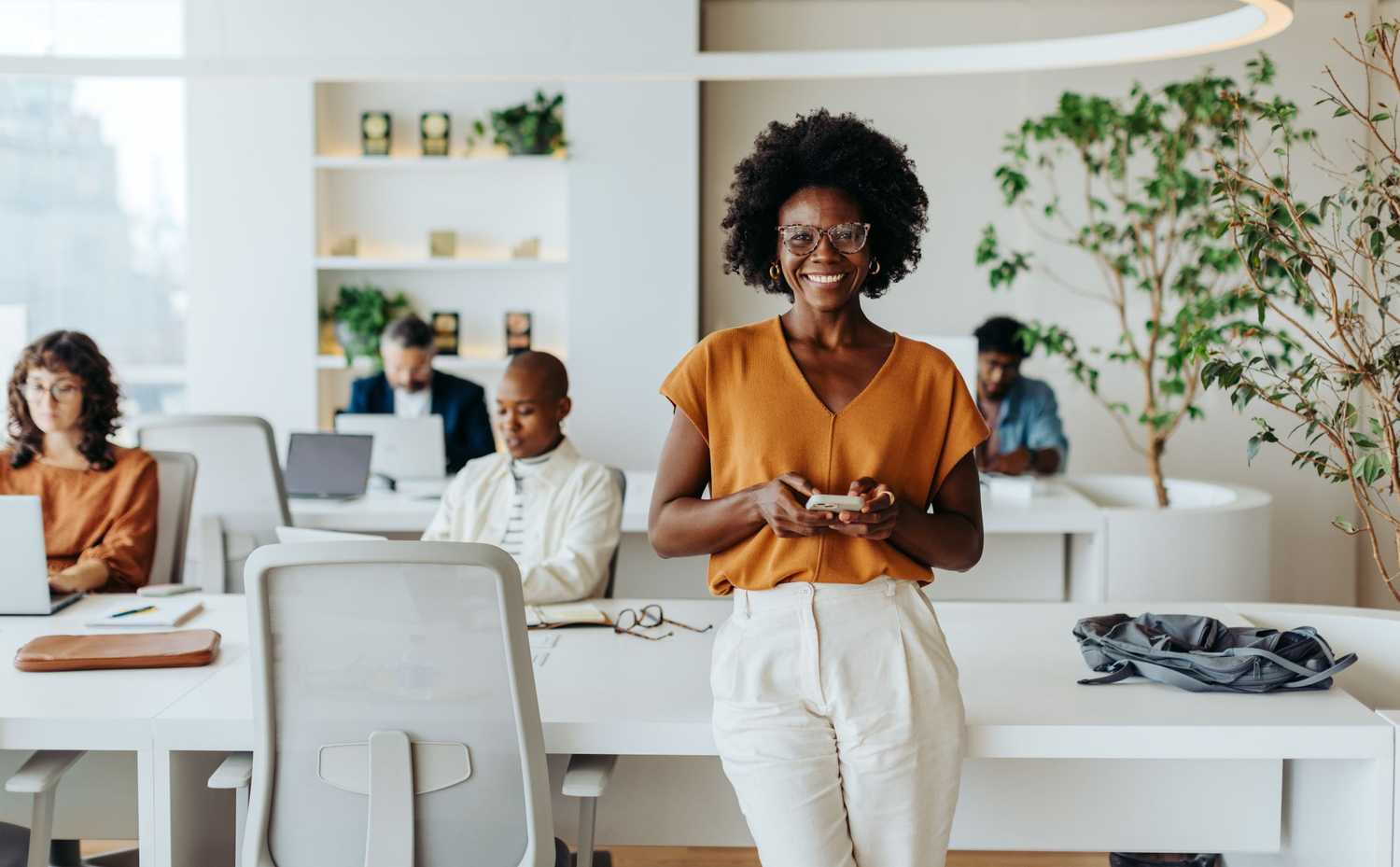 Successful woman in modern office using smartphone